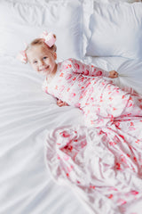 Cupcakes and Bows Bamboo Two-Piece Pajama Set - Lifestyle on Bed - Pink Cupcake Bamboo Pajamas with Matching Blanket