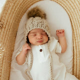 Oatmeal cable knit baby bonnet back view showing tie closure and soft cotton texture