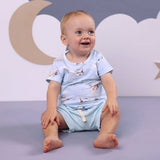 Smiling baby boy wearing Taking Flight vintage aircraft print organic cotton tee with pale blue shorts