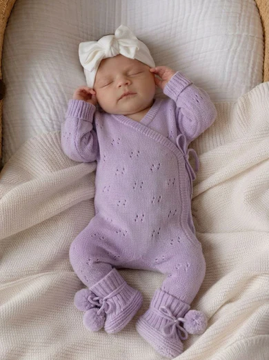 Orchid purple pointelle knit baby romper, detail of side-tie closure and lace-like openwork texture