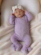 Orchid purple pointelle knit baby romper, detail of side-tie closure and lace-like openwork texture