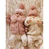 Flat lay of natural baby cardigan with fur collar showing full garment design and proportions