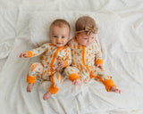 Two babies sitting in matching Little Sprouts Soluna bamboo zippies on white blanket