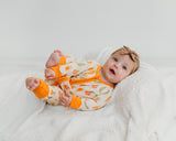Baby wearing Little Sprouts Soluna bamboo zippy with bow headband on white blanket