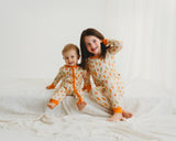 Three smiling children wearing matching Little Sprouts Soluna bamboo two-piece pajamas on white bed