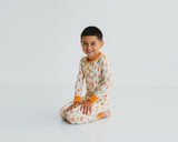 Smiling boy sitting in Little Sprouts Soluna bamboo two-piece pajamas