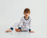 Boy sitting in Harbor Dreams Soluna bamboo two-piece pajamas with sailboat print