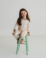 Girl sitting on mint stool wearing Desert Dawn Soluna bamboo two-piece pajamas