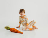 Child wearing Little Sprouts Soluna bamboo two-piece pajamas with carrot prop