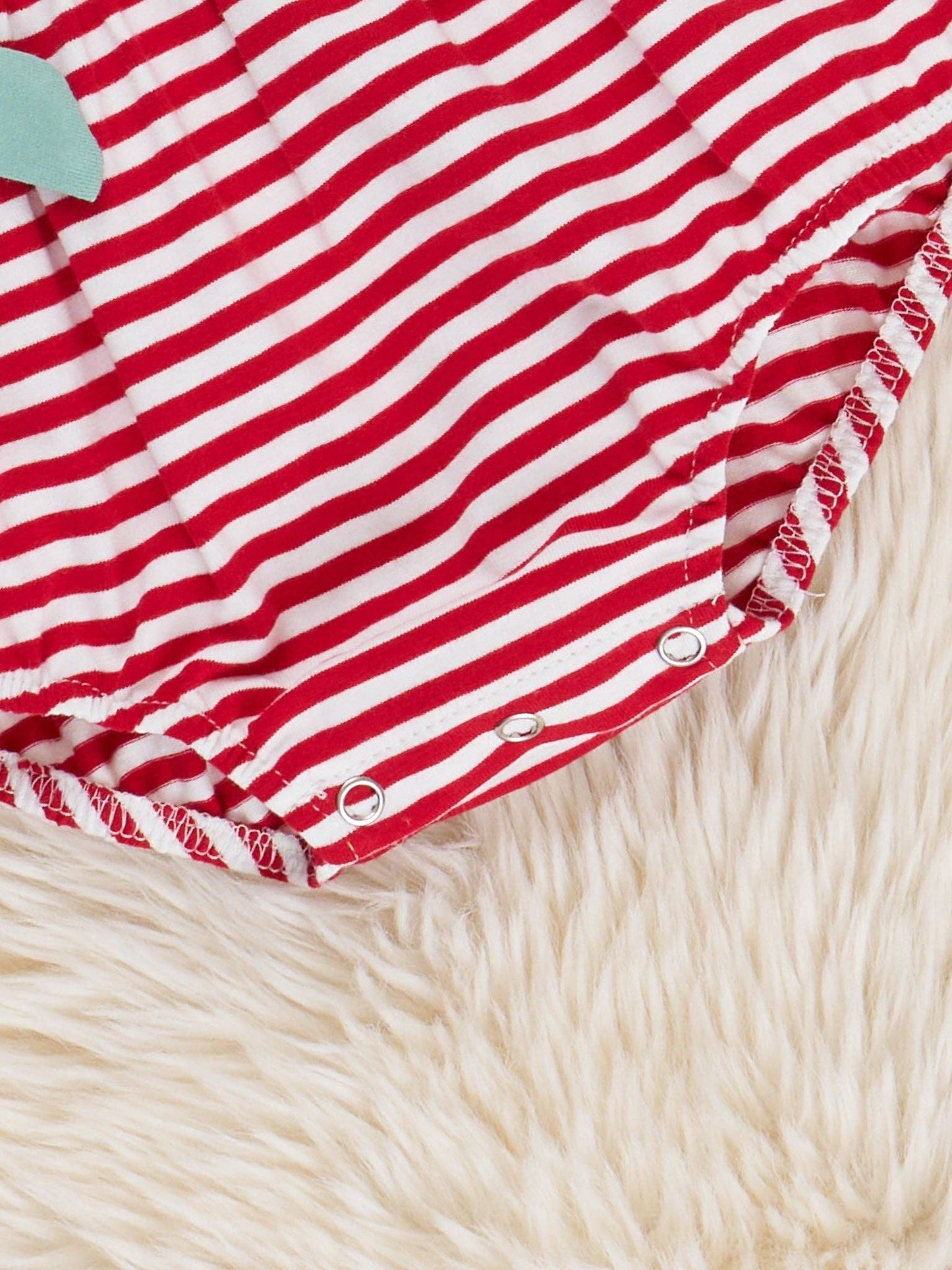 Back view of Watermelon Stripes Smocked Cotton Ruffle Bubble Romper showing striped pattern and snap button closure on baby girl romper