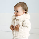 Close-up detail of fur collar on natural baby cardigan showing luxurious texture and craftsmanship