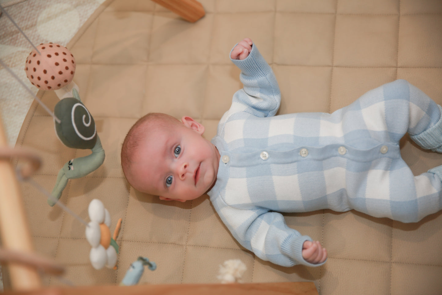 Baby wearing blue gingham knit romper - close up lifestyle shot