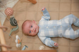 Baby wearing blue gingham knit romper - close up lifestyle shot
