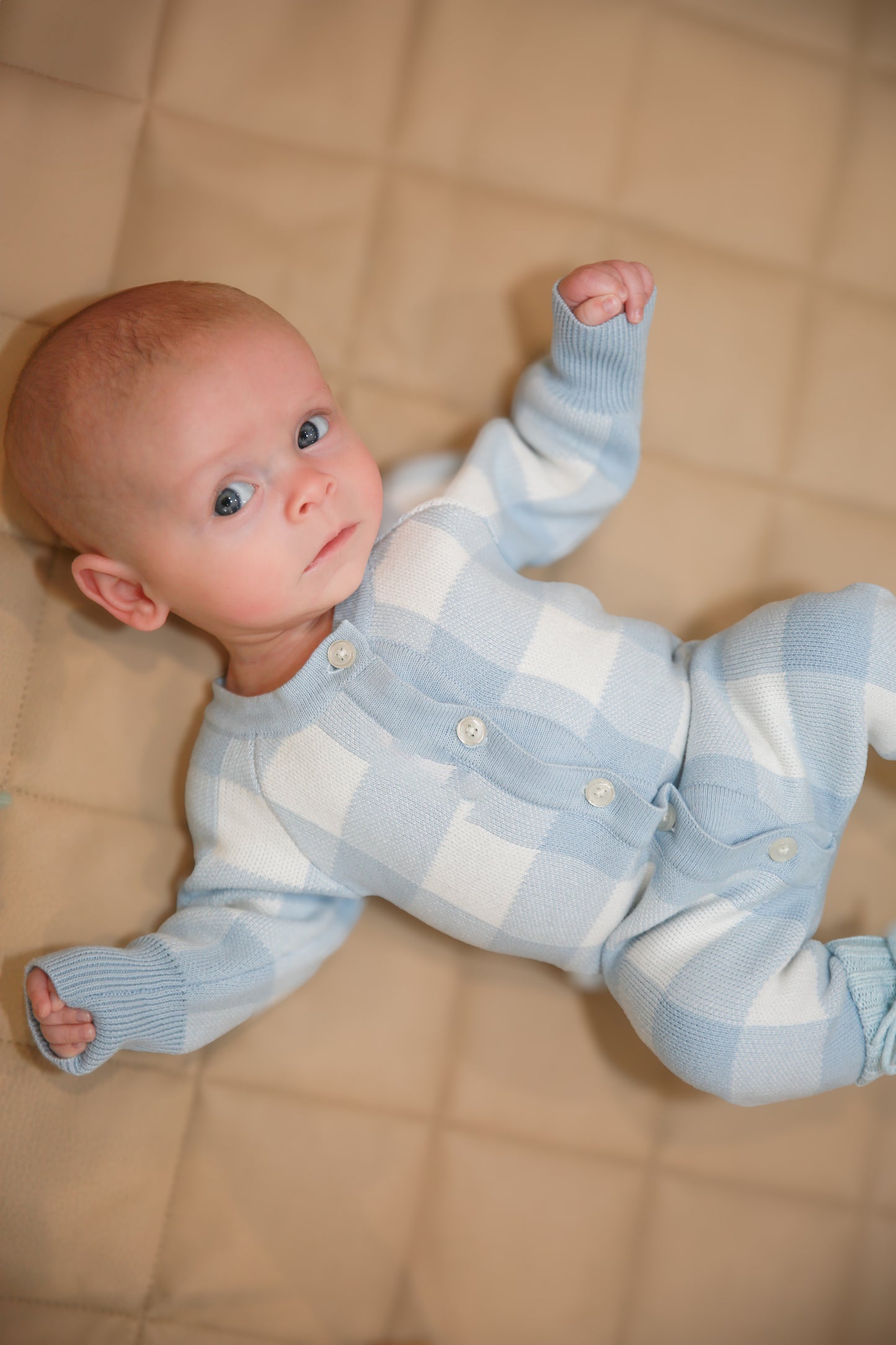 Baby in blue gingham knit romper - detail button closure shot