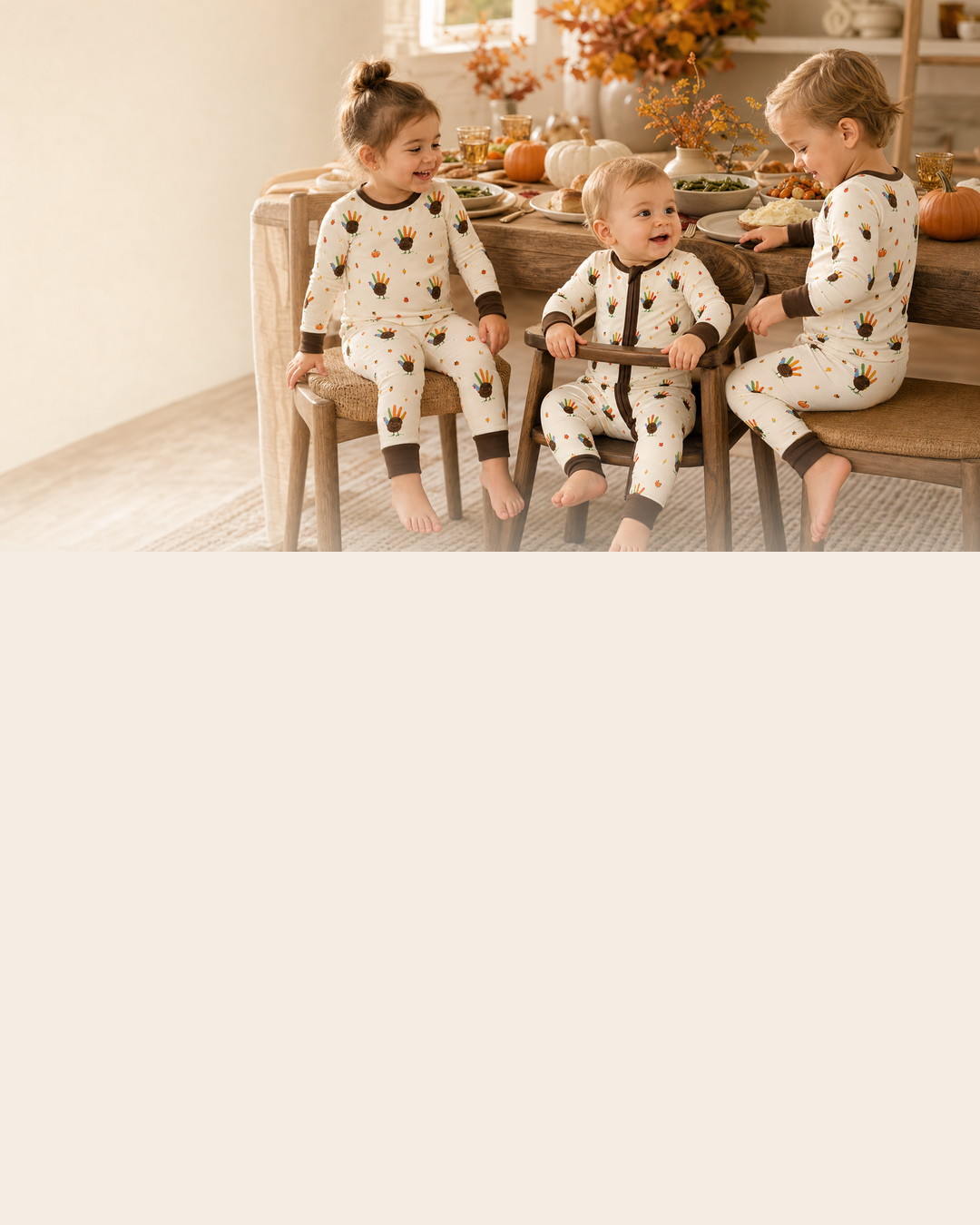 Babies and toddlers wearing Feathered Friend pajamas at a warm Thanksgiving dinner table