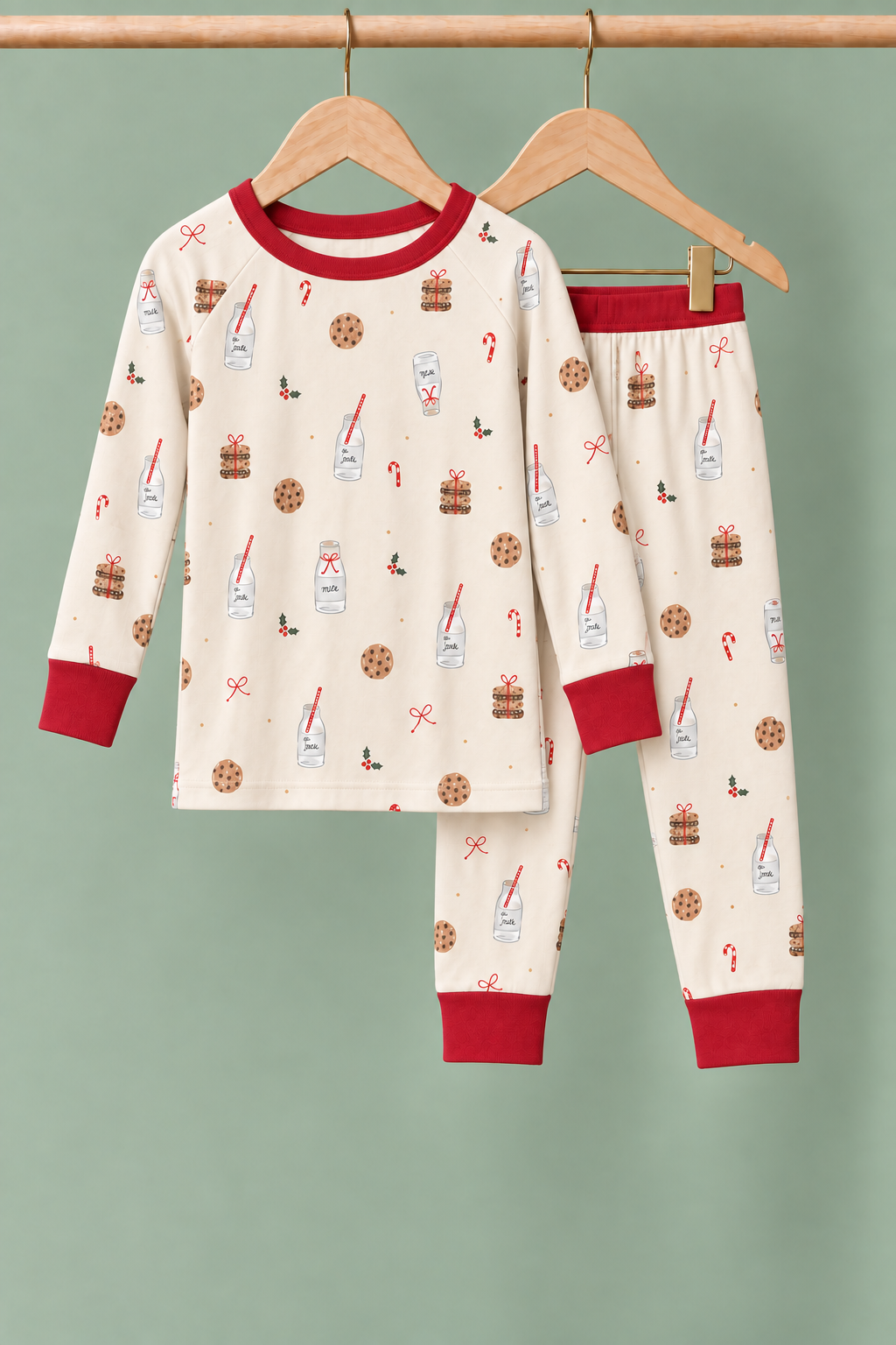 Milk & Cookies Zinza™ Toddler Two-Piece Pajama Set on wooden hangers against a sage background