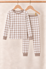 Mocha Gingham kids two-piece pajamas with taupe trim on wooden hangers against a cream background