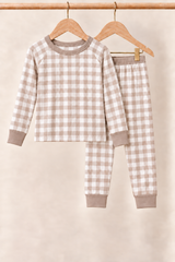 Mocha Gingham toddler two-piece pajamas with taupe trim on wooden hangers against a cream background