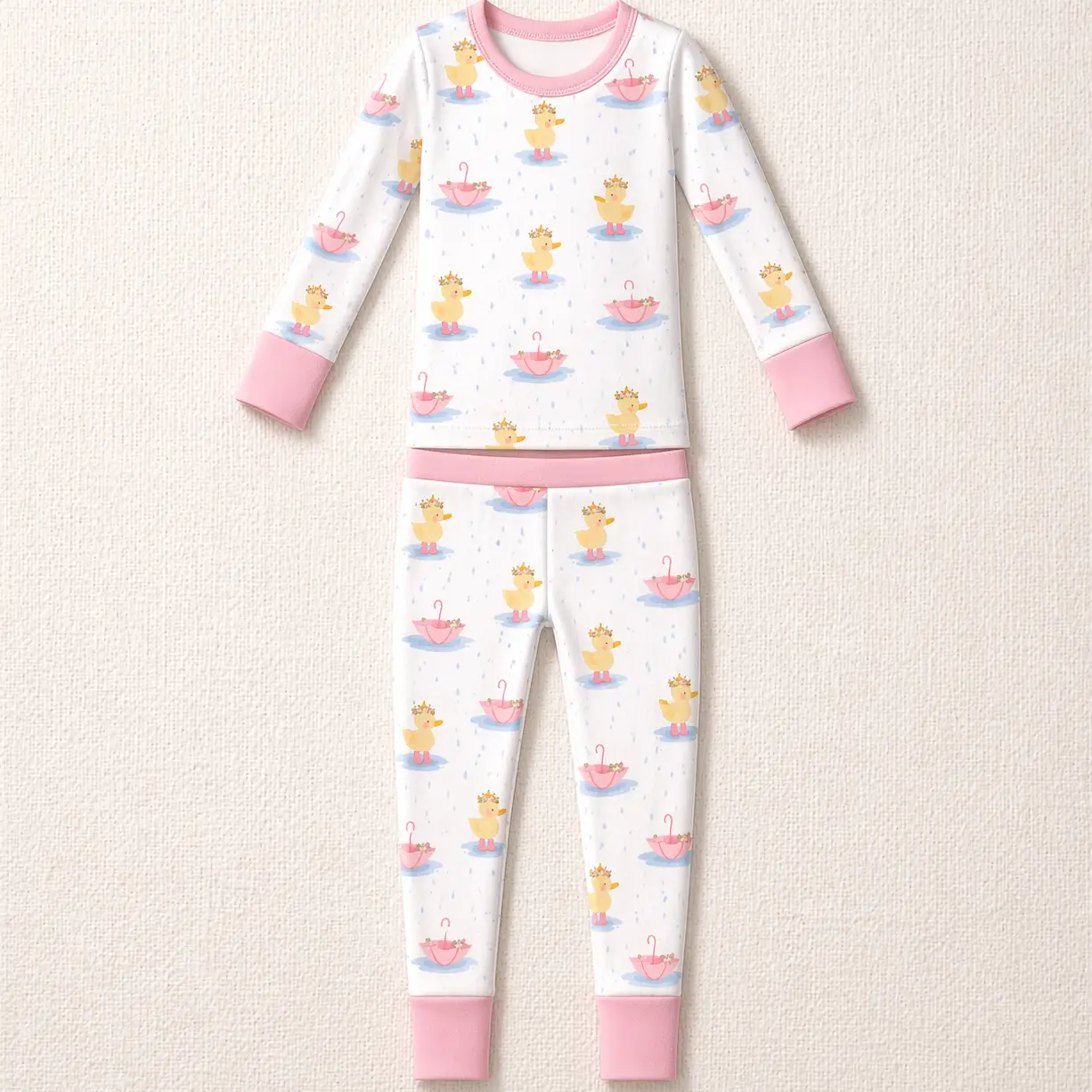 Royal Ducklings Long Sleeve Pajamas by The Honey and Bro Co. - Bamboo pajama set flat lay with pink trim and duckling rain print