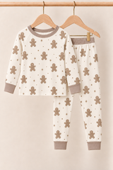 Winter Gingerbread Zinza™ Toddler Two-Piece Pajama Set on wooden hangers against a warm cream background