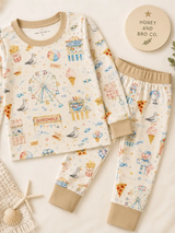 Boardwalk Baby toddler pajama top and pants with Ferris wheels, seagulls and ice cream motifs, styled beside seashells